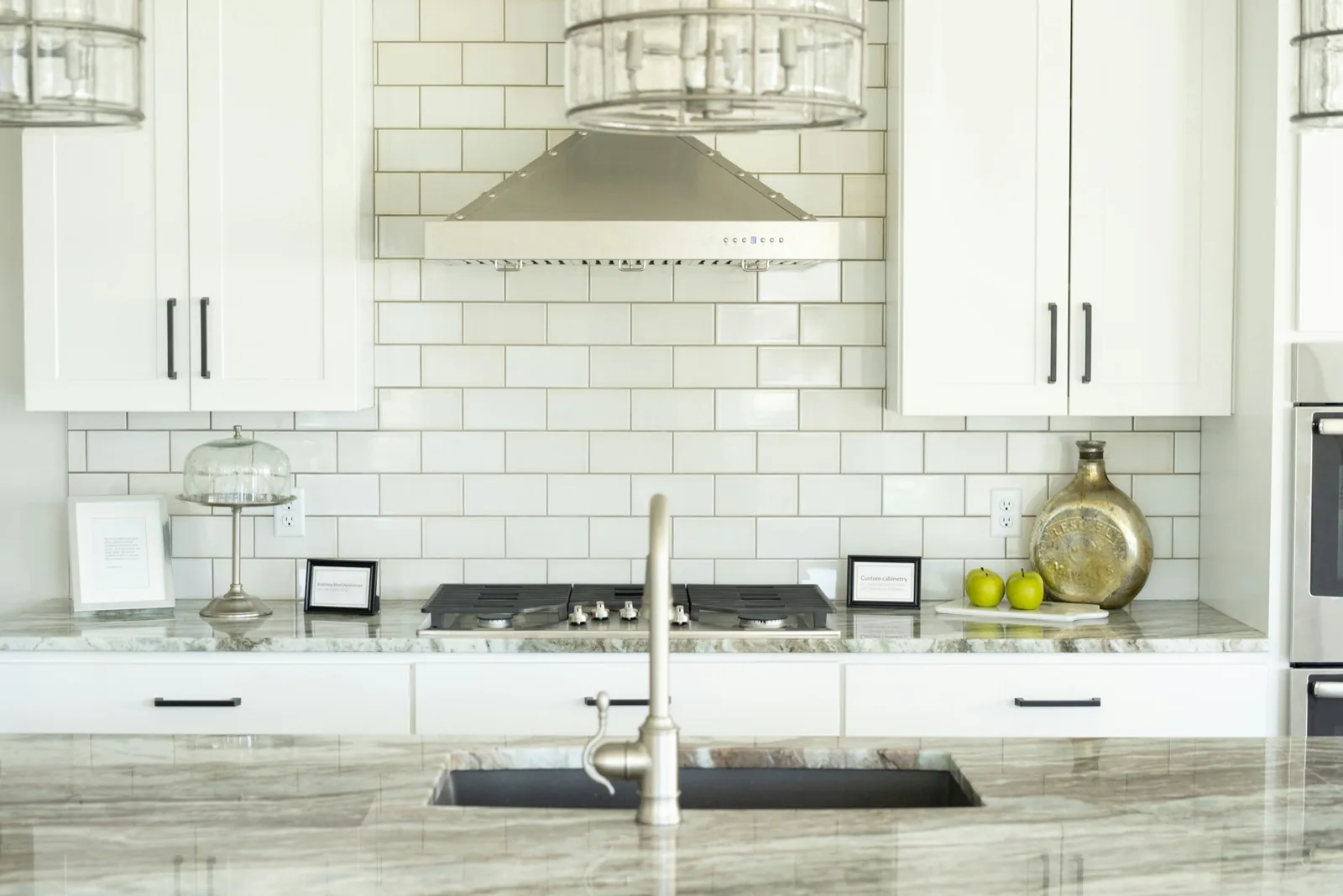 Bright, freshly cleaned kitchen with white cabinets and marble countertops